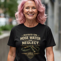Woman wearing a black t-shirt with text and graphics, standing on a sidewalk.