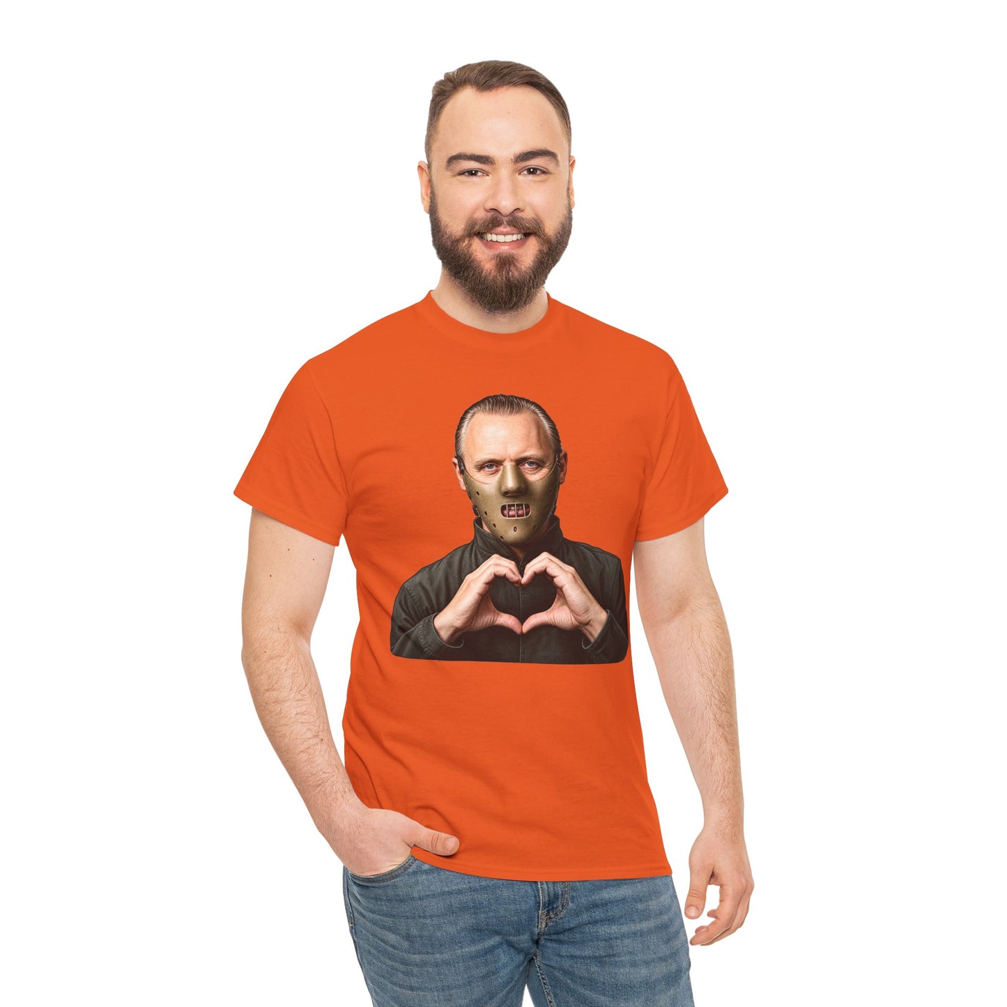 A man wearing a bright orange crewneck t-shirt with a graphic print of a zombie making a heart shape with his hands. The background is solid white.