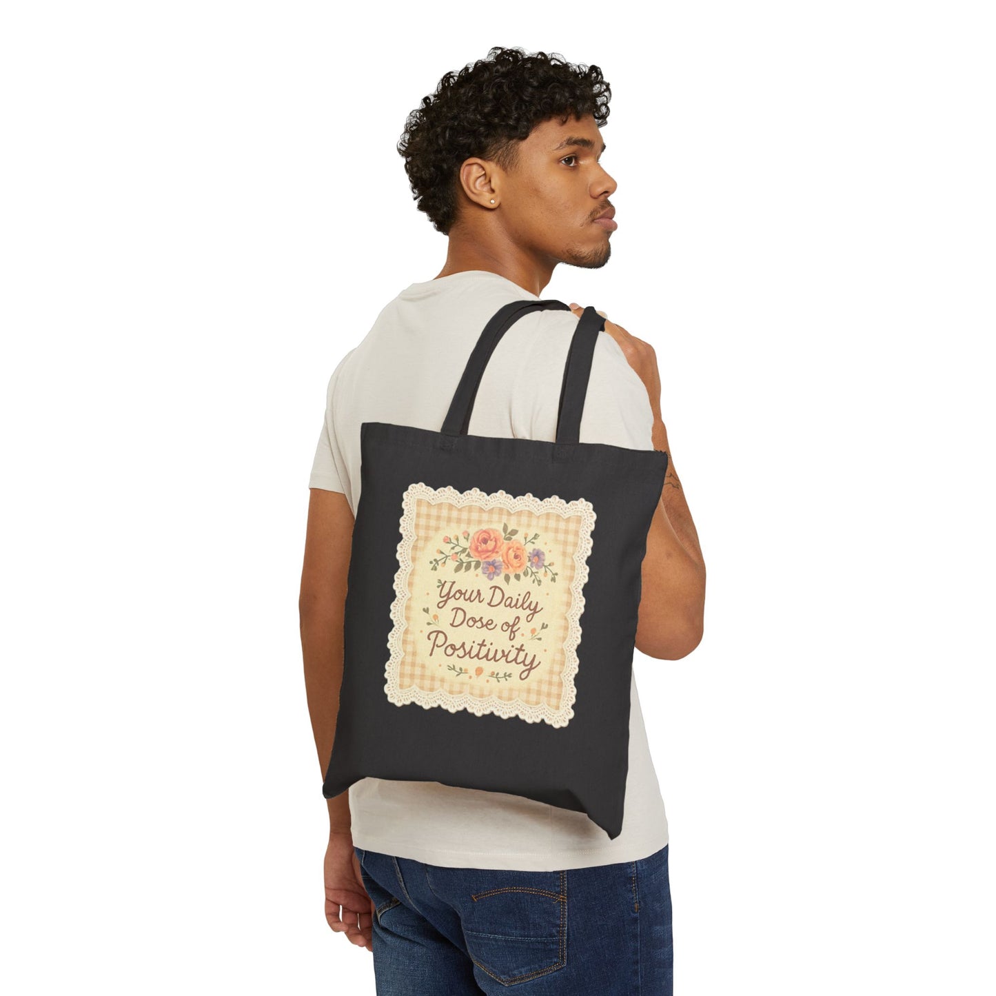 Man carrying a black tote bag with a motivational quote and floral design on a white background
