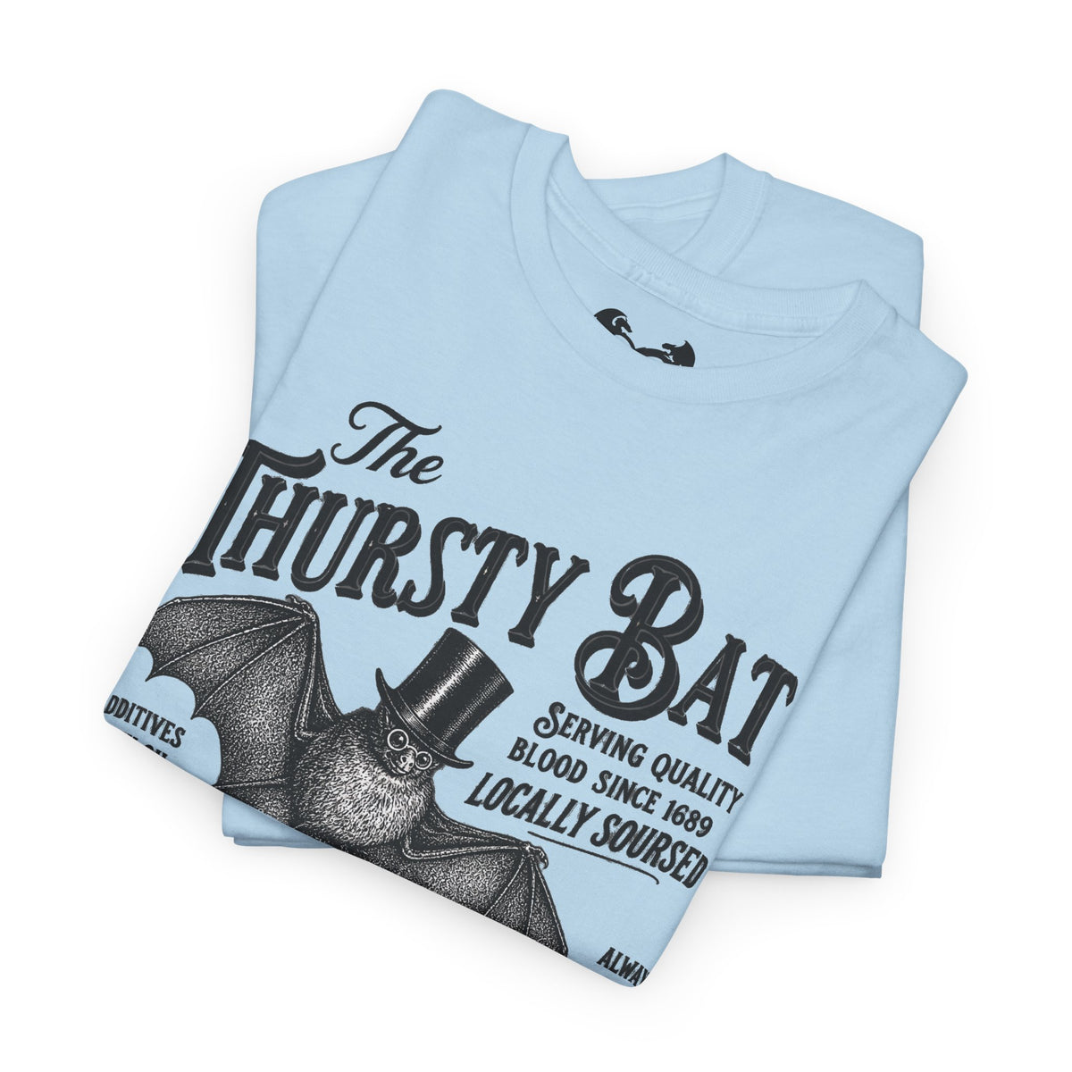 A light blue folded t-shirt featuring a vintage-style black graphic of a bat wearing a top hat with the text 'The Thirsty Bat' and 'Serving quality blood, since 1689'.