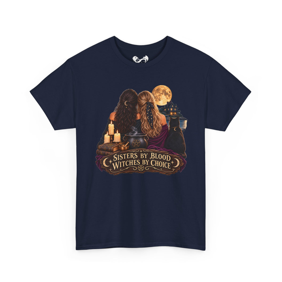 A navy blue short-sleeve t-shirt with a graphic print on the front depicting two witches with long hair, cauldrons, candles, and a full moon, with the text 'SISTERS BY BLOOD WITCHES BY CHOICE'.