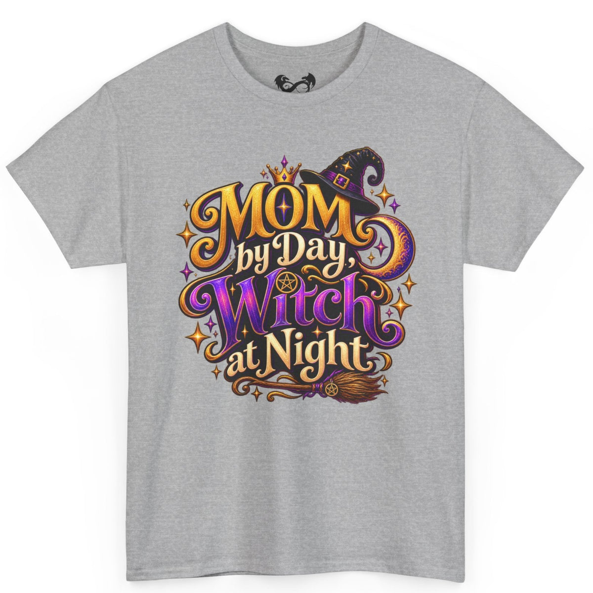 A heather gray short-sleeve crewneck t-shirt featuring a colorful graphic on the front that reads 'MOM by Day, Witch at Night' in stylized purple, orange, and gold lettering with a witch hat and broomstick illustration.