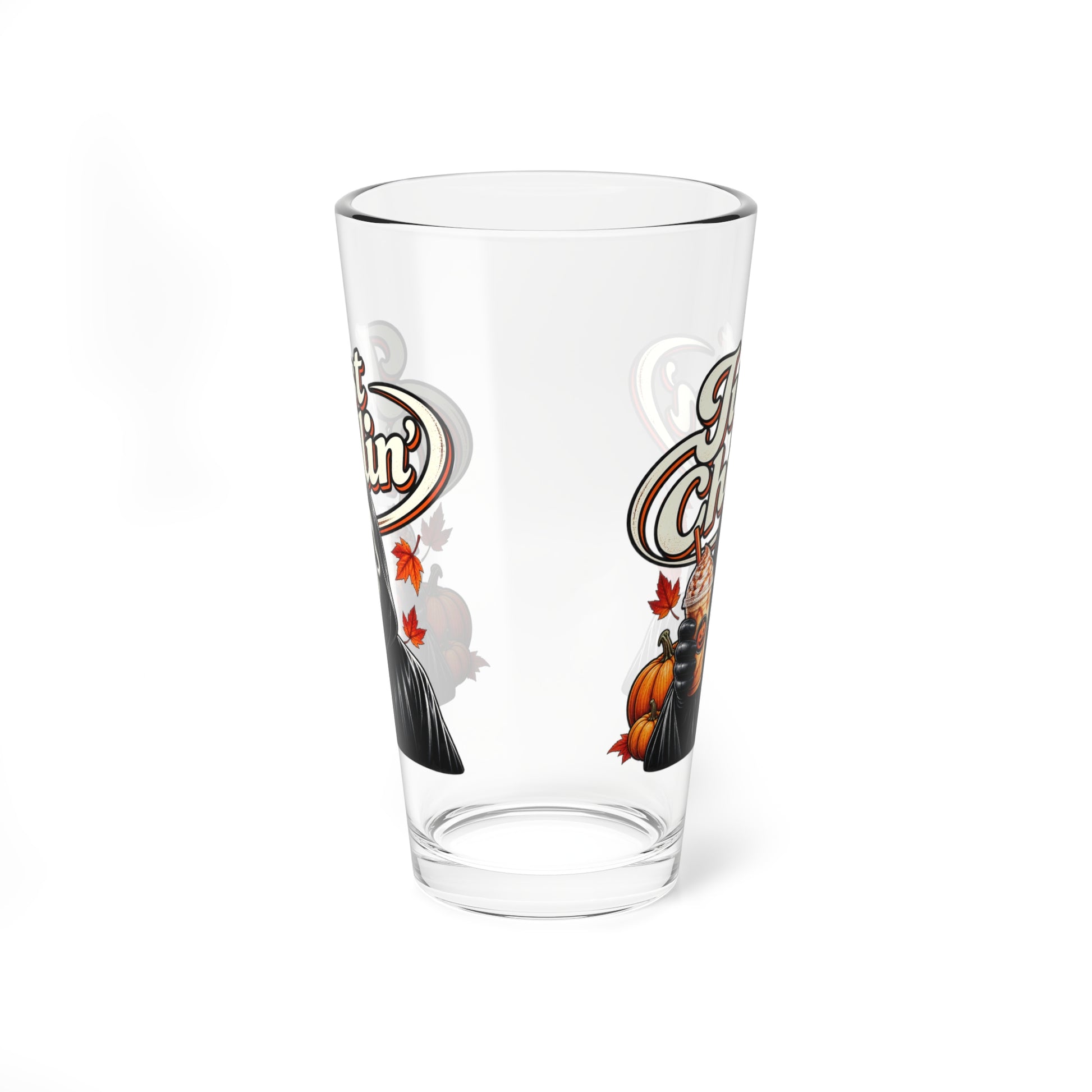 A clear pint glass with a decorative autumn-themed graphic featuring a pumpkin, leaves, and stylized lettering, shown on a plain white background.