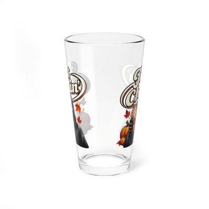 A clear pint glass with a decorative autumn-themed graphic featuring a pumpkin, leaves, and stylized lettering, shown on a plain white background.