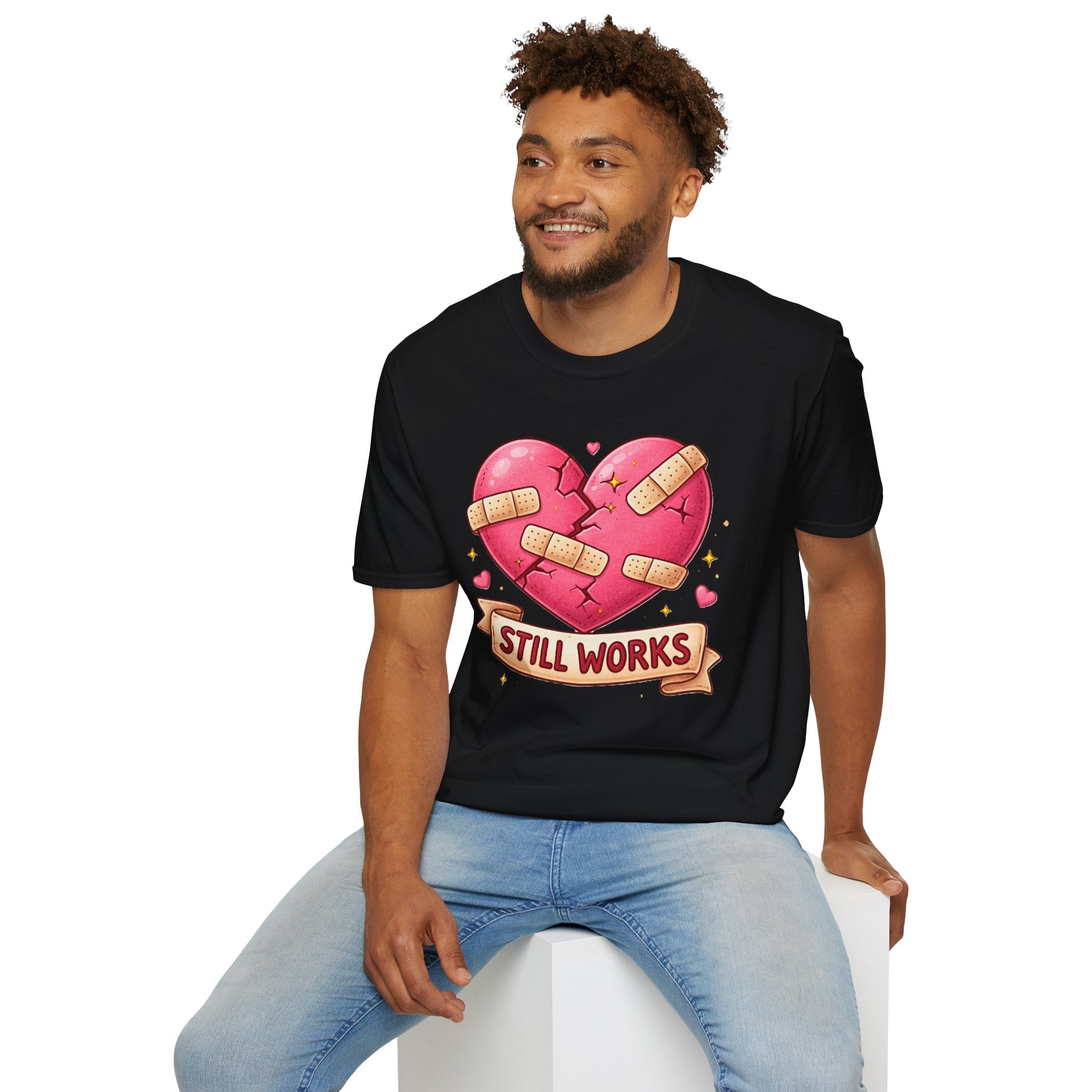 Man wearing a black t-shirt with a heart design and 'STILL WORKS' text on a white background