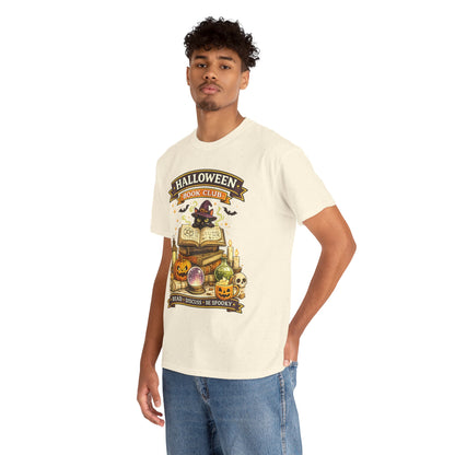 A man wearing a cream-colored t-shirt with a 'Halloween Magic Club' graphic print, paired with blue jeans, standing against a plain white background.