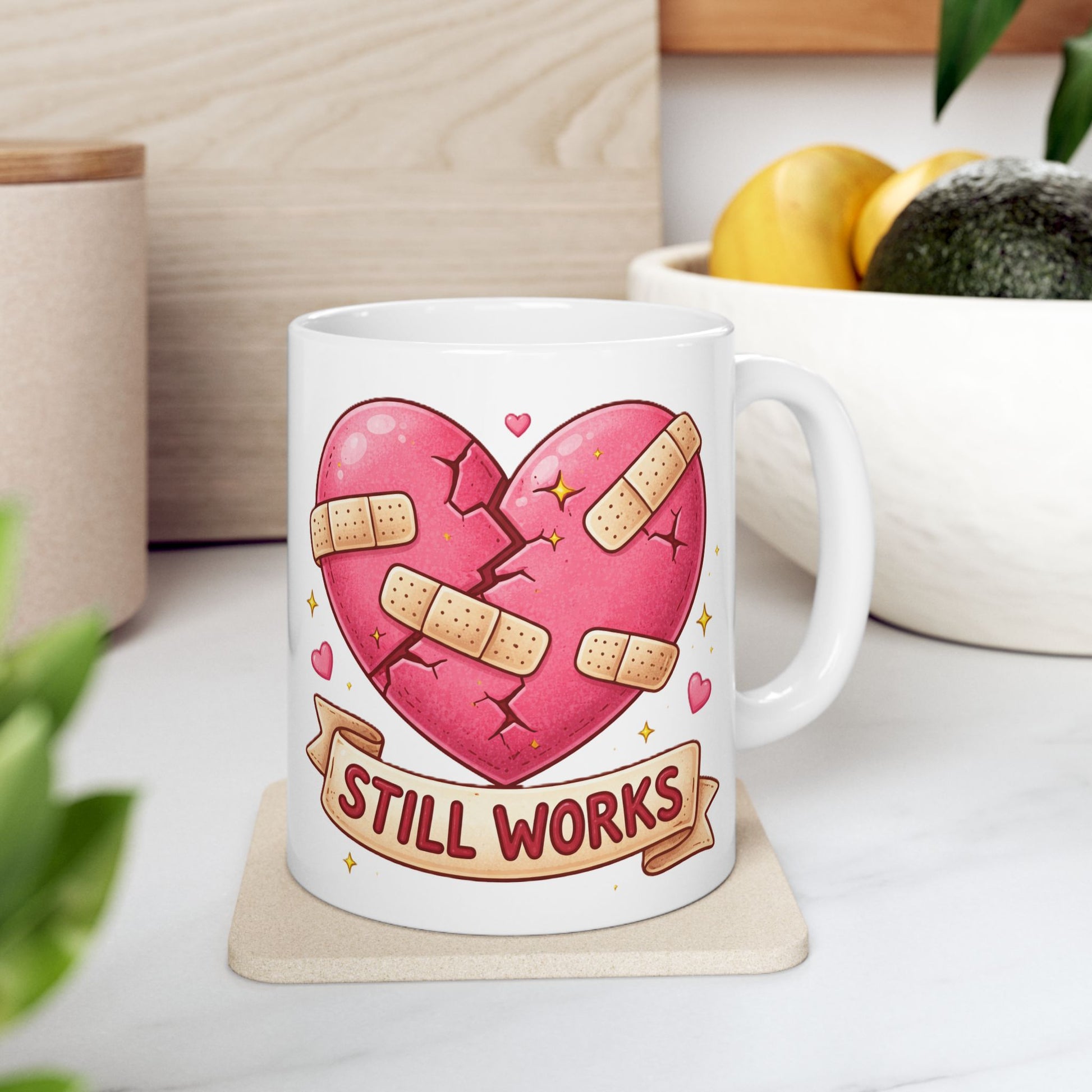 Mug with a heart design and 'Still Works' text on a table.