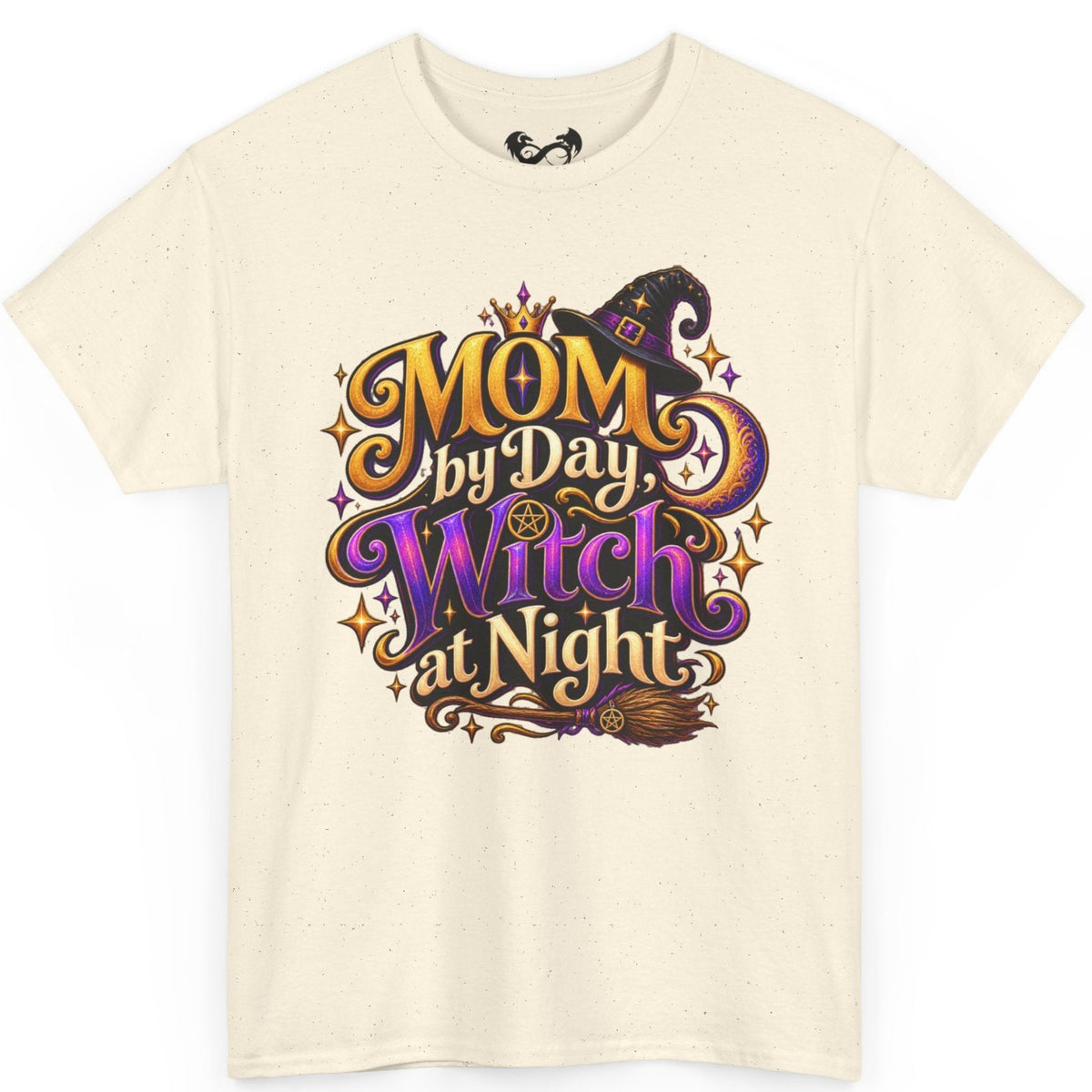 An off-white short-sleeve t-shirt with a colorful graphic on the front that reads 'MOM by Day, Witch at Night' in stylized purple, orange, and gold lettering with a witch hat and broomstick illustration.