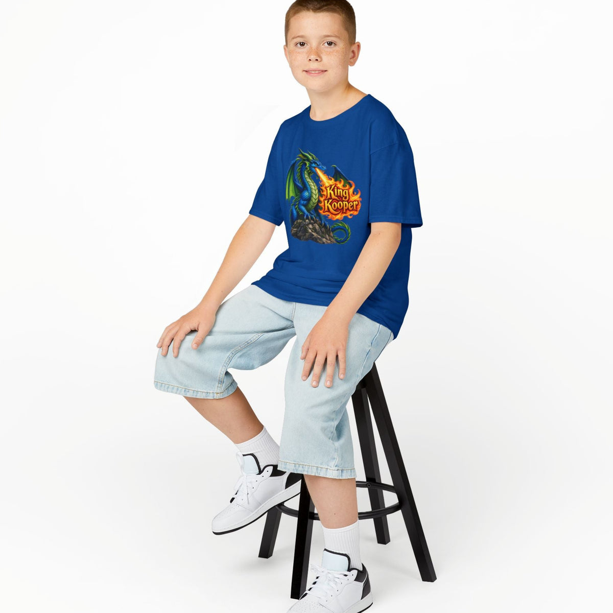 Child wearing a blue t-shirt with 'Gaming Mode On' design, sitting on a stool against a white background