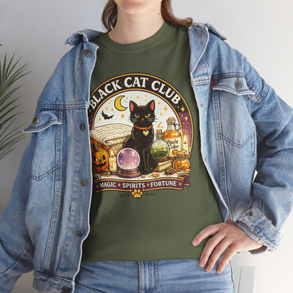 A woman wearing an olive green graphic t-shirt with a 'Black Cat Club' Halloween design, styled with an open light-wash denim jacket.