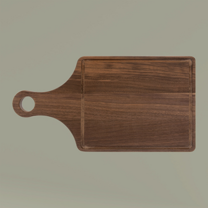 Wooden cutting board with handle on a beige background