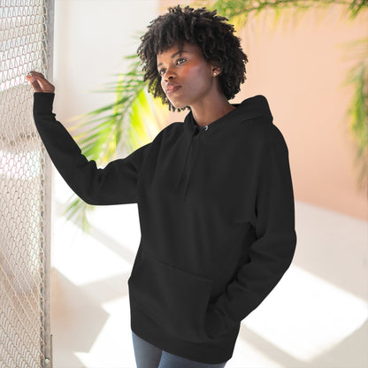 Person wearing a black hoodie with a colorful design, standing indoors with plants in the background.