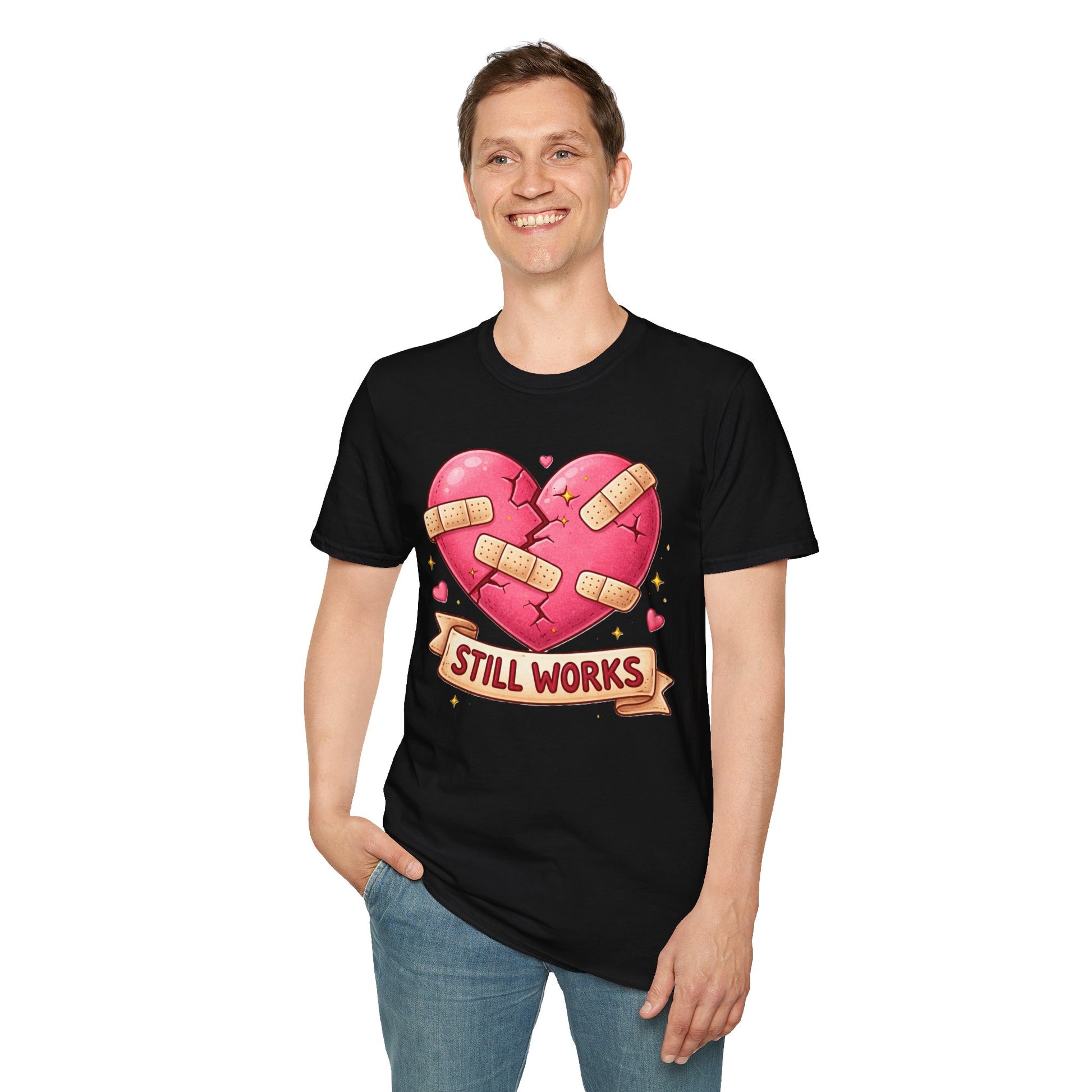 Person wearing a black t-shirt with a pink heart design and 'Still Works' text on a white background