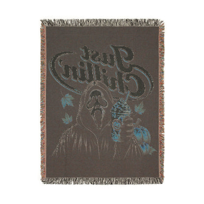 A rectangular woven throw blanket with fringe on all sides, featuring a dark brown background and a stylized graphic of a bear head with blue and light blue accents and the text 'Crazy Bear'.