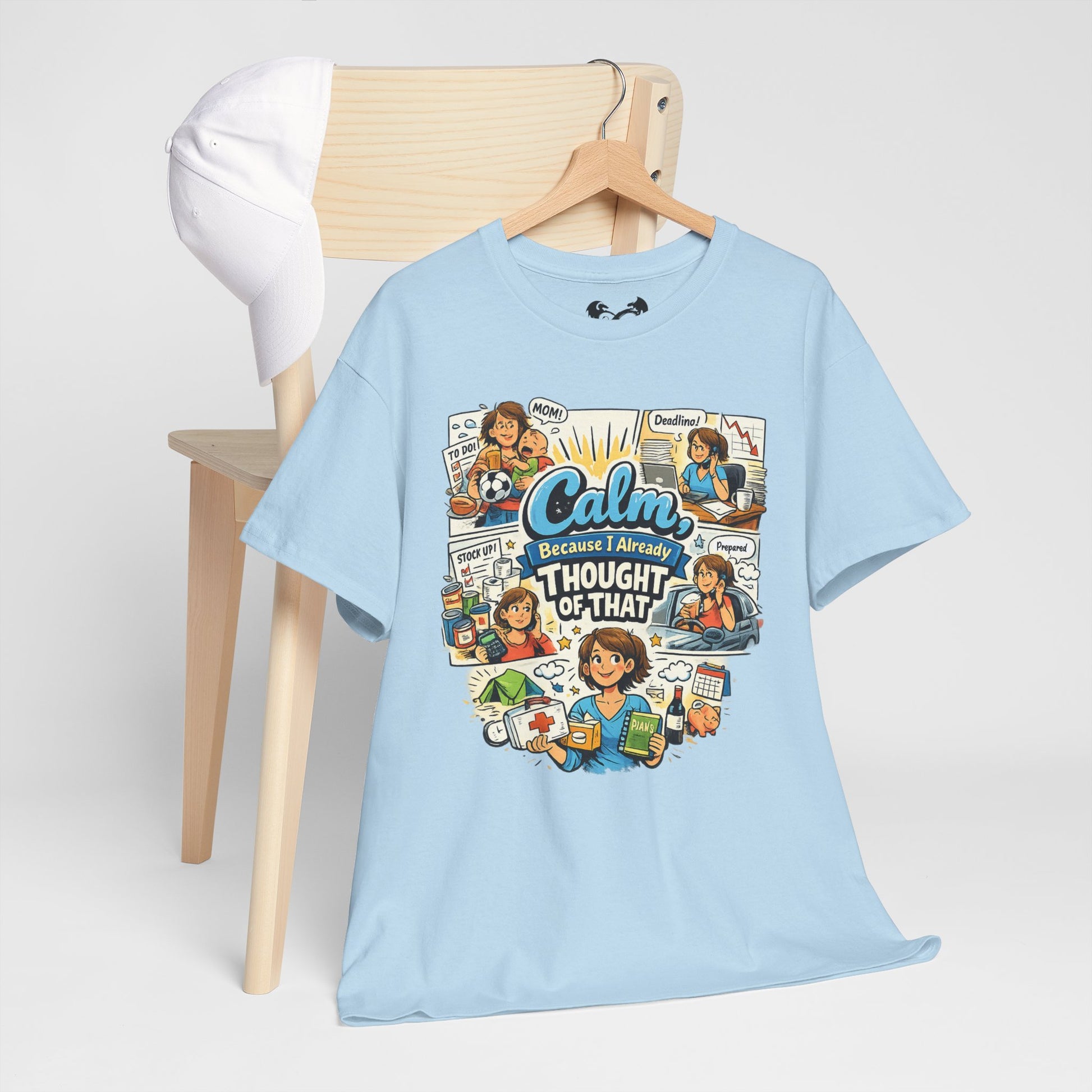 Light blue t-shirt with colorful graphic design on a wooden chair against a white background