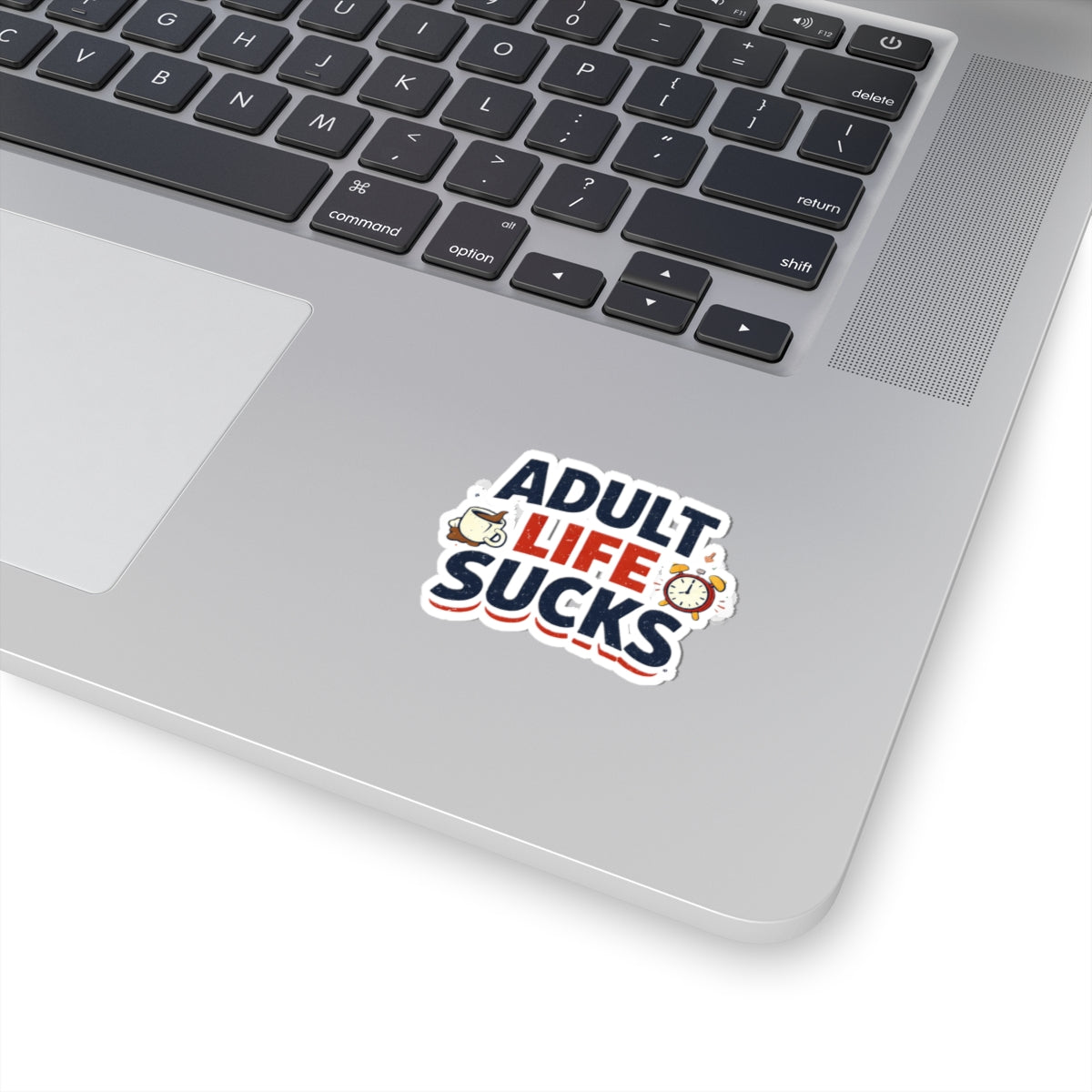 Laptop with a 'Adult Life Sucks' sticker on the palm rest area