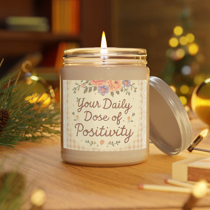 Candle in a jar with a label 'Your Daily Dose of Positivity' on a wooden surface with decorative background.