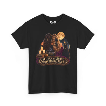 A black short-sleeve crewneck t-shirt with a graphic print on the front depicting two witches with long hair, cauldrons, candles, and a full moon, with the text 'SISTERS BY BLOOD WITCHES BY CHOICE'.