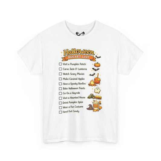 A white short-sleeve crewneck t-shirt featuring a 'Halloween Bucket List' graphic on the front. The graphic includes a checklist of spooky activities with illustrations of pumpkins, bats, a ghost, a haunted house, and a cauldron.