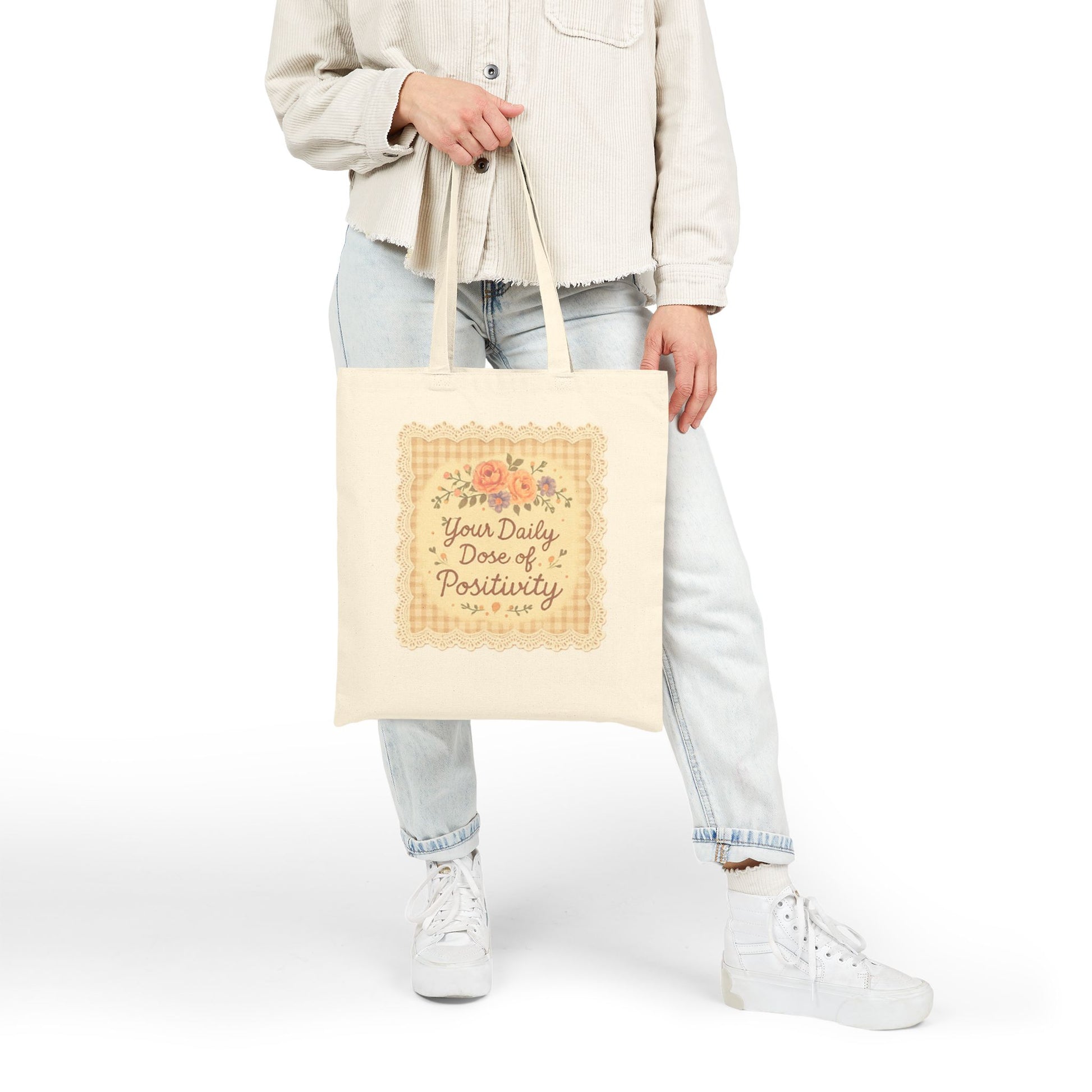 Person holding a tote bag with a motivational quote on a white background