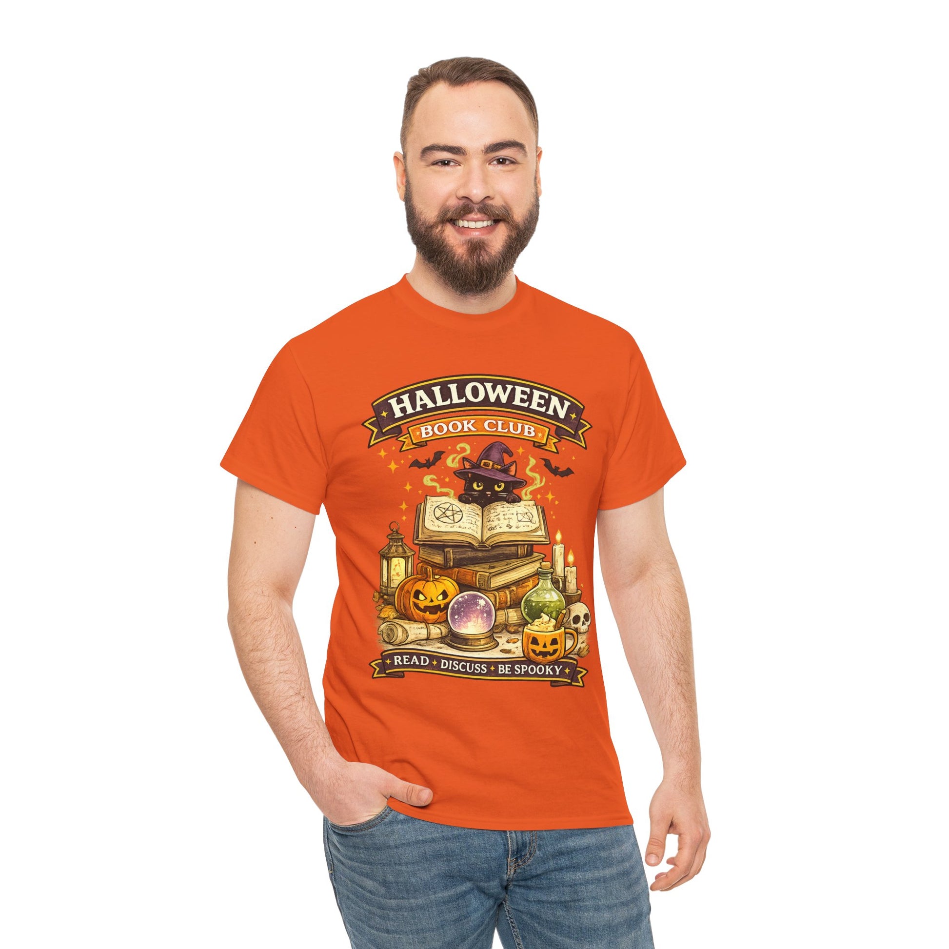 A man wearing a bright orange graphic t-shirt with a 'Halloween Book Club' design, paired with blue jeans, standing against a plain white background.