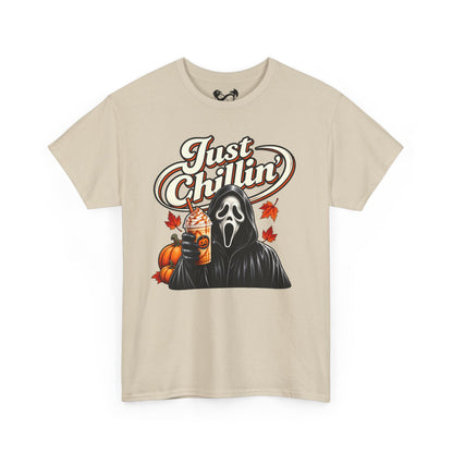 A beige short-sleeve crewneck t-shirt featuring a graphic print of Ghostface from Scream holding an iced coffee with pumpkin and maple leaf accents, under the text 'Just Chillin''.