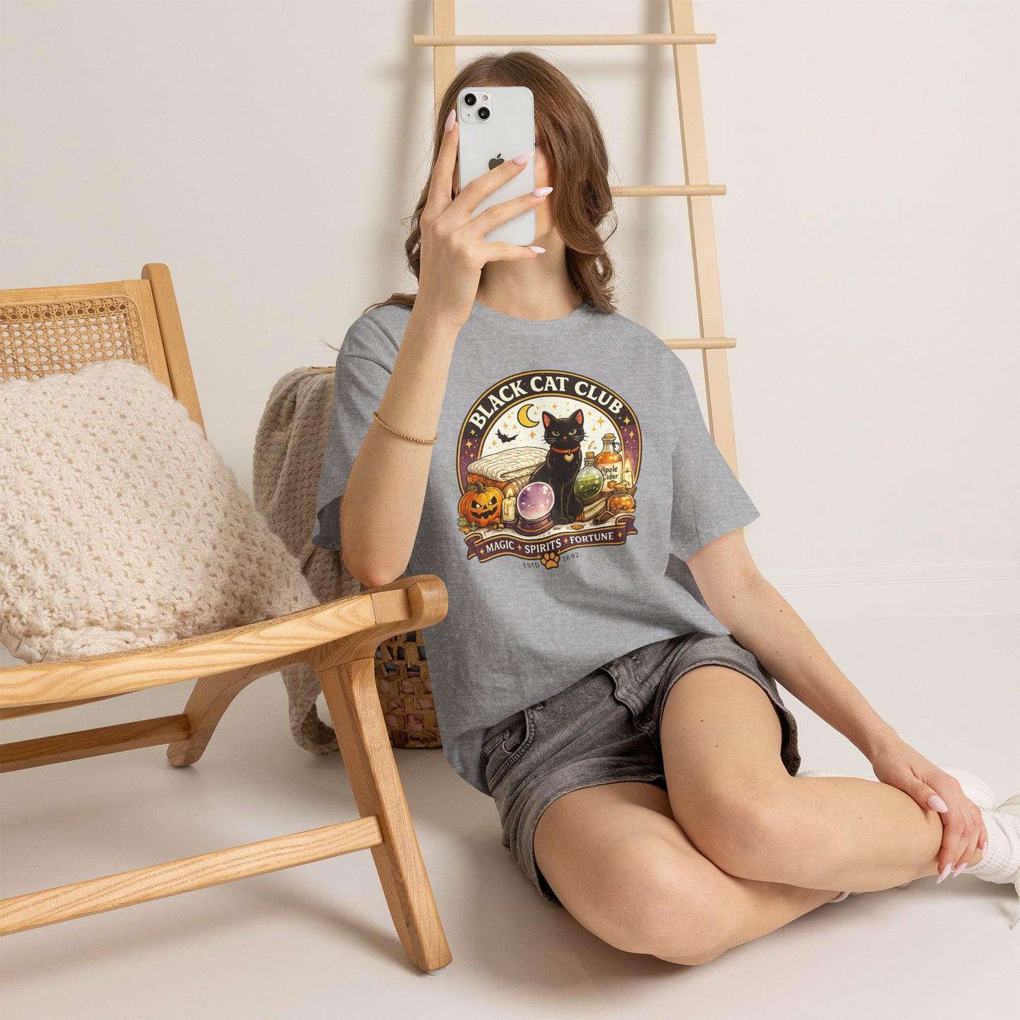 Person wearing a t-shirt with a graphic design sitting on the floor.