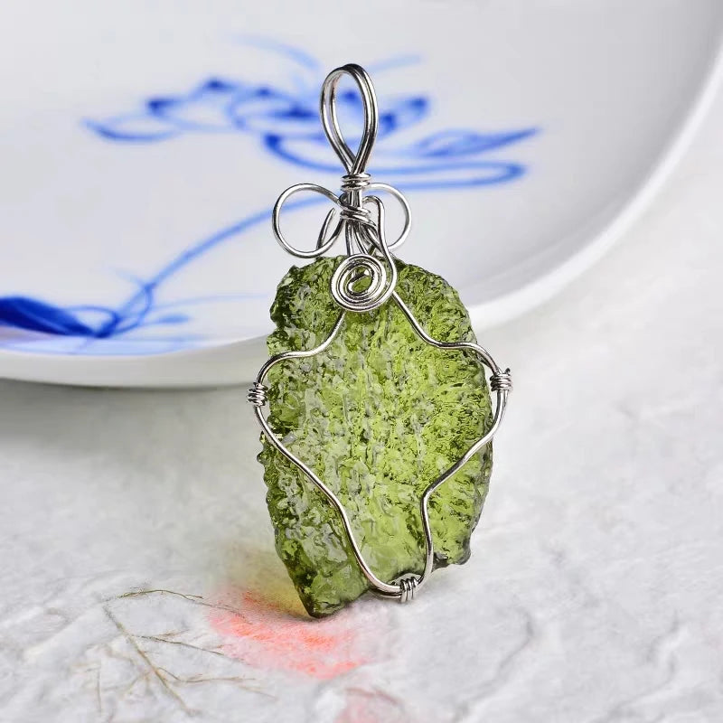 Discover the unique beauty of natural green moldavite with our stunning necklace. Created by the natural force of meteorite impact, this necklace boasts a one-of-a-kind natural shape and impressive dark green hue. Add a touch of rare elegance to your jewelry collection with this incredible piece.