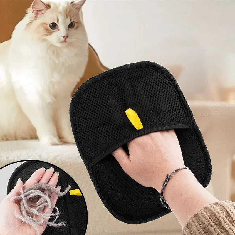 Black pet grooming tool with yellow tag held by a person, with a cat in the background.