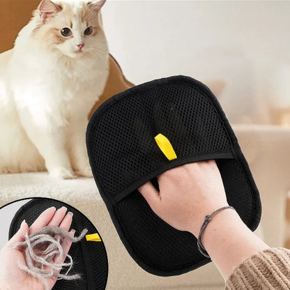 Black pet grooming tool with yellow tag held by a person, with a cat in the background.