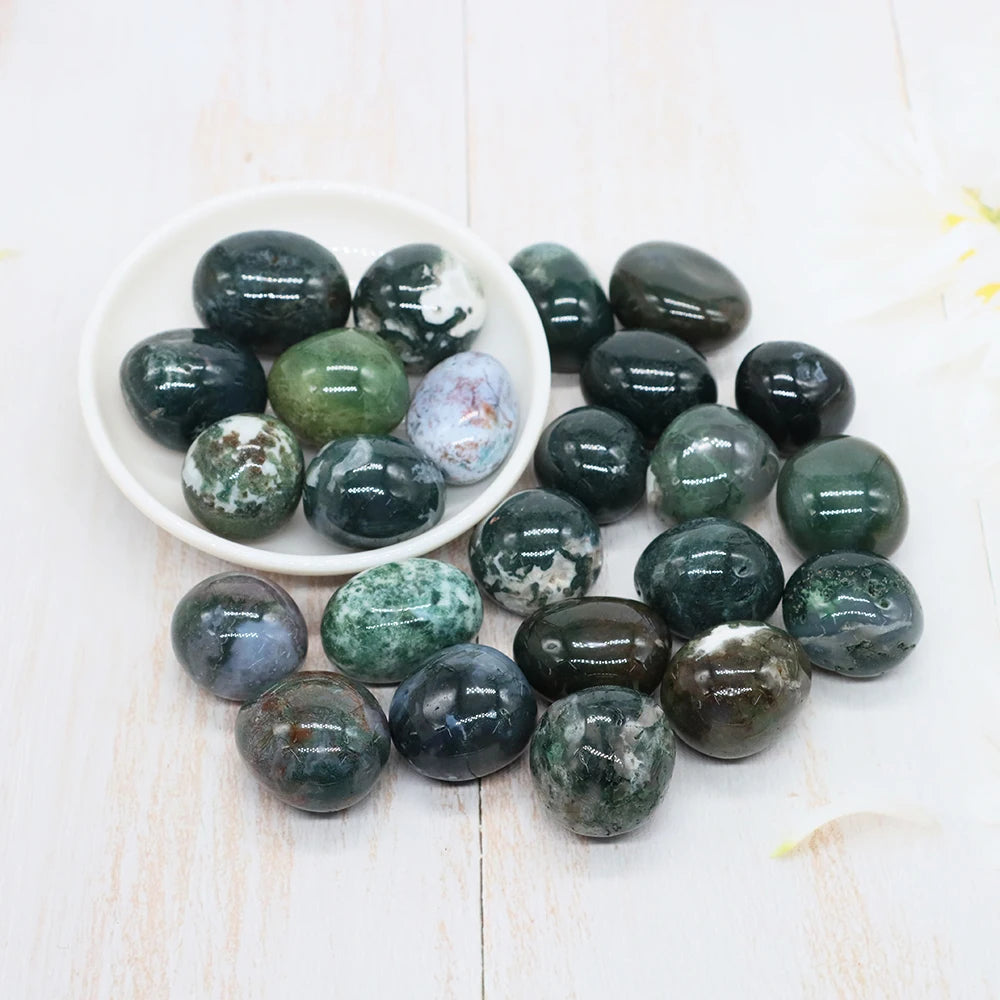 Collection of green and brown marbled stones on a white surface