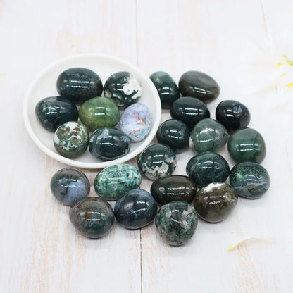 Collection of green and brown marbled stones on a white surface