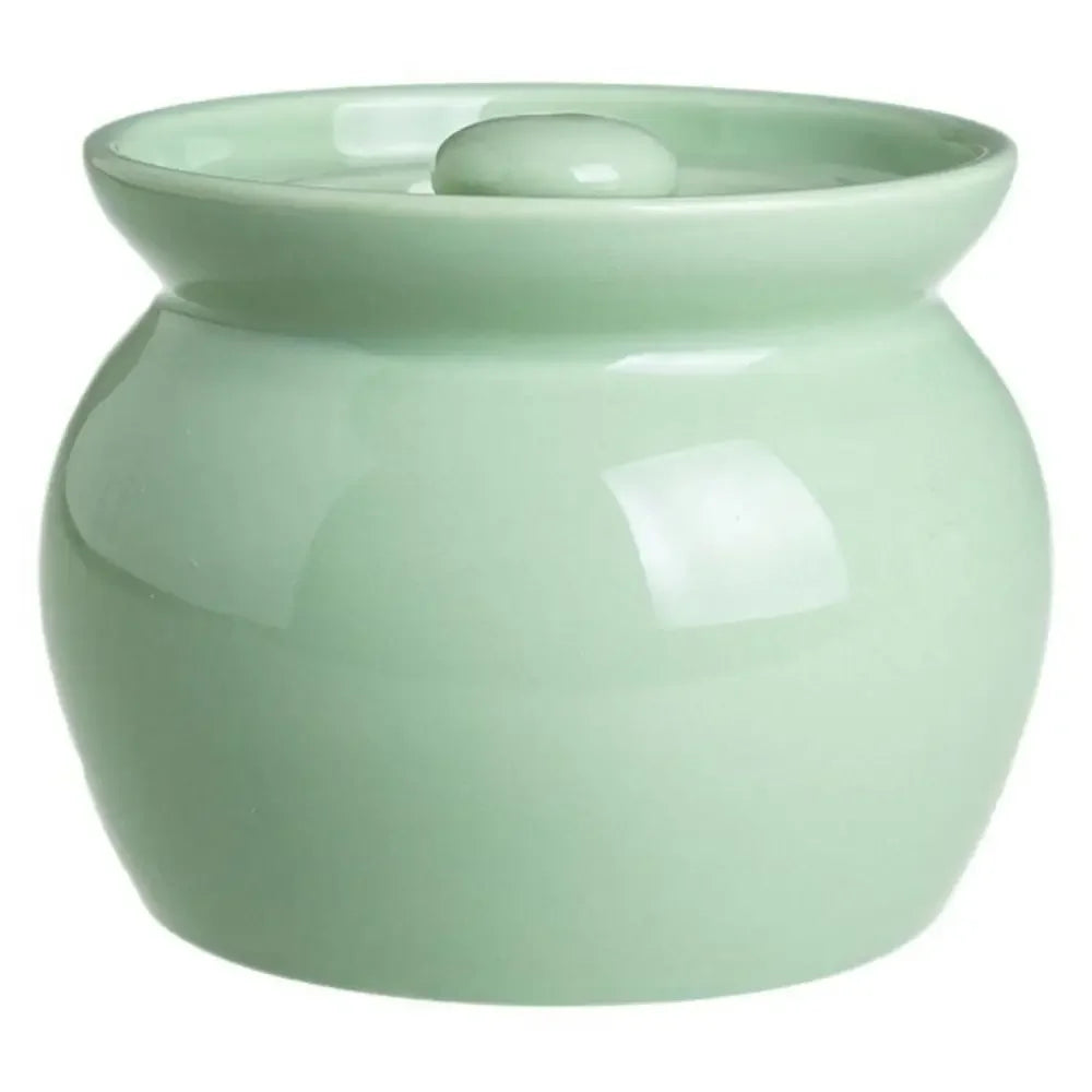Green ceramic pot with a lid on a white background