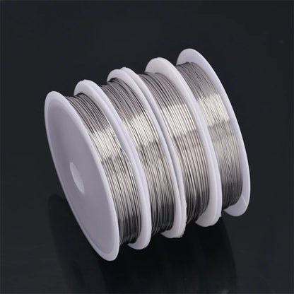 Spool of silver wire on a black background