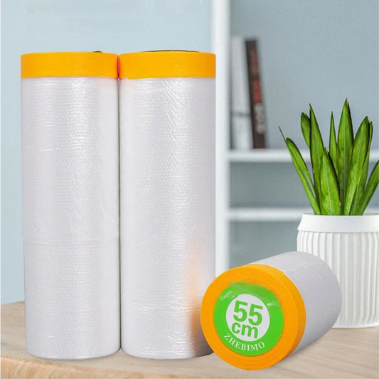 Two rolls of white tape with orange ends on a wooden surface, with a plant in the background.