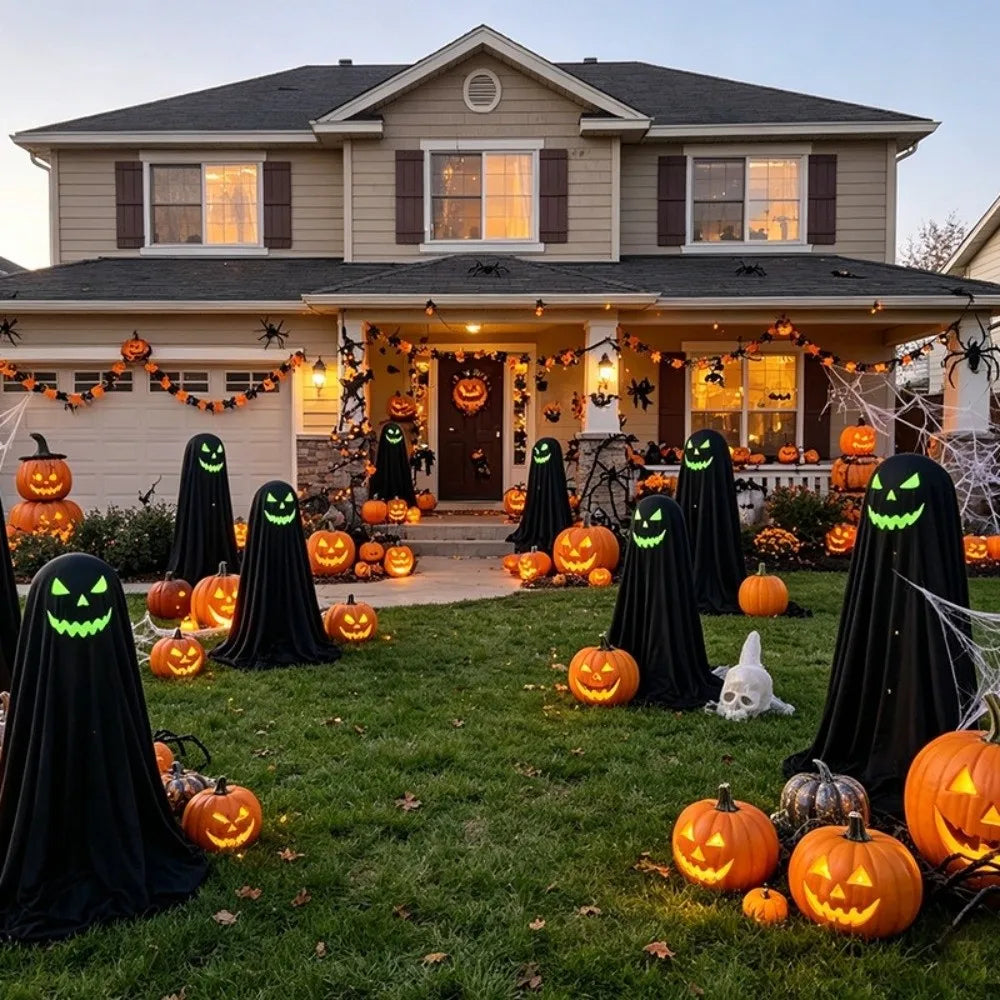 A suburban house front yard decorated for Halloween with numerous black ghost figures, glowing jack-o'-lantern pumpkins, spiderwebs, and orange garlands on the lawn and porch.