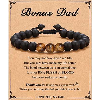 Black beaded bracelet with a message card for 'Bonus Dad' on a brown background