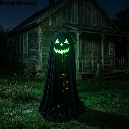 A black ghost-shaped Halloween decoration with a glowing green jack-o'-lantern face and warm string lights, standing in front of an old wooden house at night.