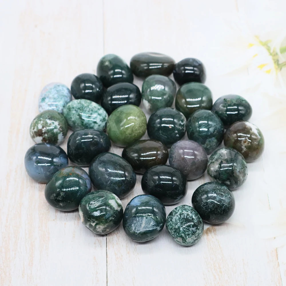 Collection of green and gray marbled stones on a light wooden surface