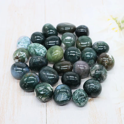 Collection of green and gray marbled stones on a light wooden surface