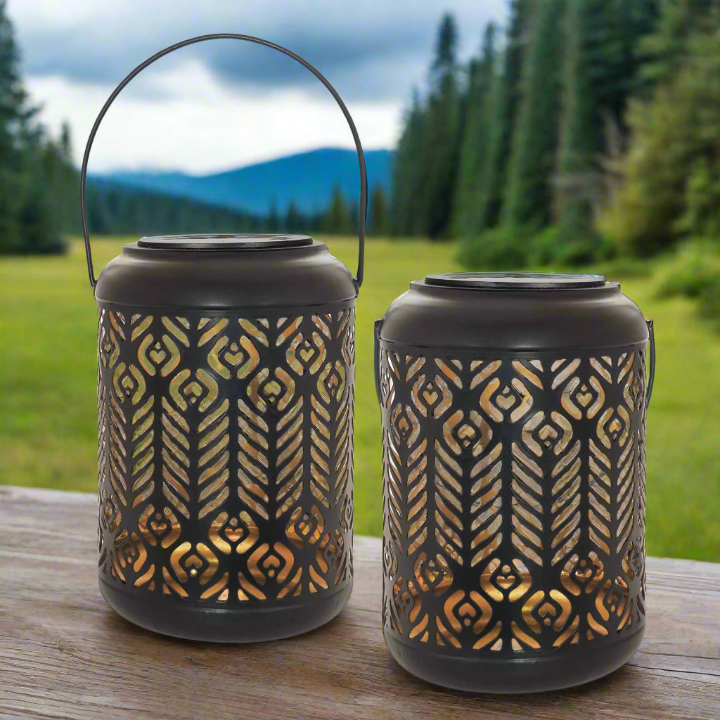 Two black lanterns with gold patterns on a white background
