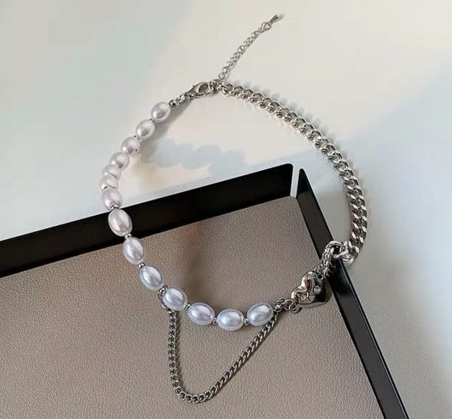 This chic Pearl & Metal Chain Heart Choker is crafted from a combination of metal and pearl chains that provide a luxuriously sophisticated look. The heart-shaped pendant adds a stylish, eye-catching detail that makes this piece a must-have accessory. Its adjustable chain ensures a comfortable, snug fit.