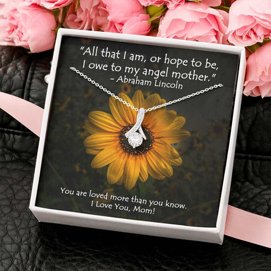 The petite ribbon shaped pendant is finished with 14K white gold over stainless steel, and is embellished with dainty clear crystals surrounded by a sparkling 7mm round cut Cubic Zirconia. 