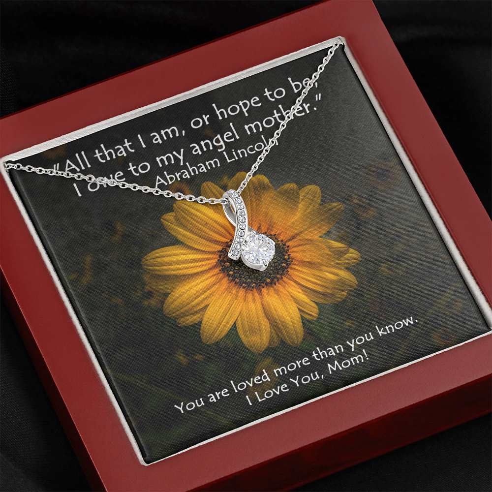 The petite ribbon shaped pendant is finished with 14K white gold over stainless steel, and is embellished with dainty clear crystals surrounded by a sparkling 7mm round cut Cubic Zirconia. 