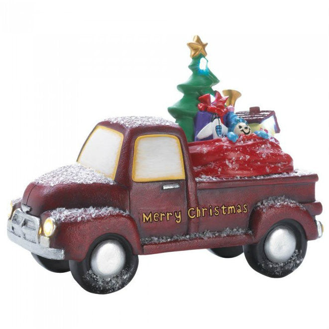 This charming old-time truck is carrying a full assortment of toys that look like they're nestled right in Santa's bag. The red truck reads "Merry Christmas" in gold on the side. The headlights light up as well as some of the toys.