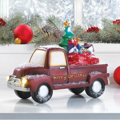 This charming old-time truck is carrying a full assortment of toys that look like they're nestled right in Santa's bag. The red truck reads "Merry Christmas" in gold on the side. The headlights light up as well as some of the toys.